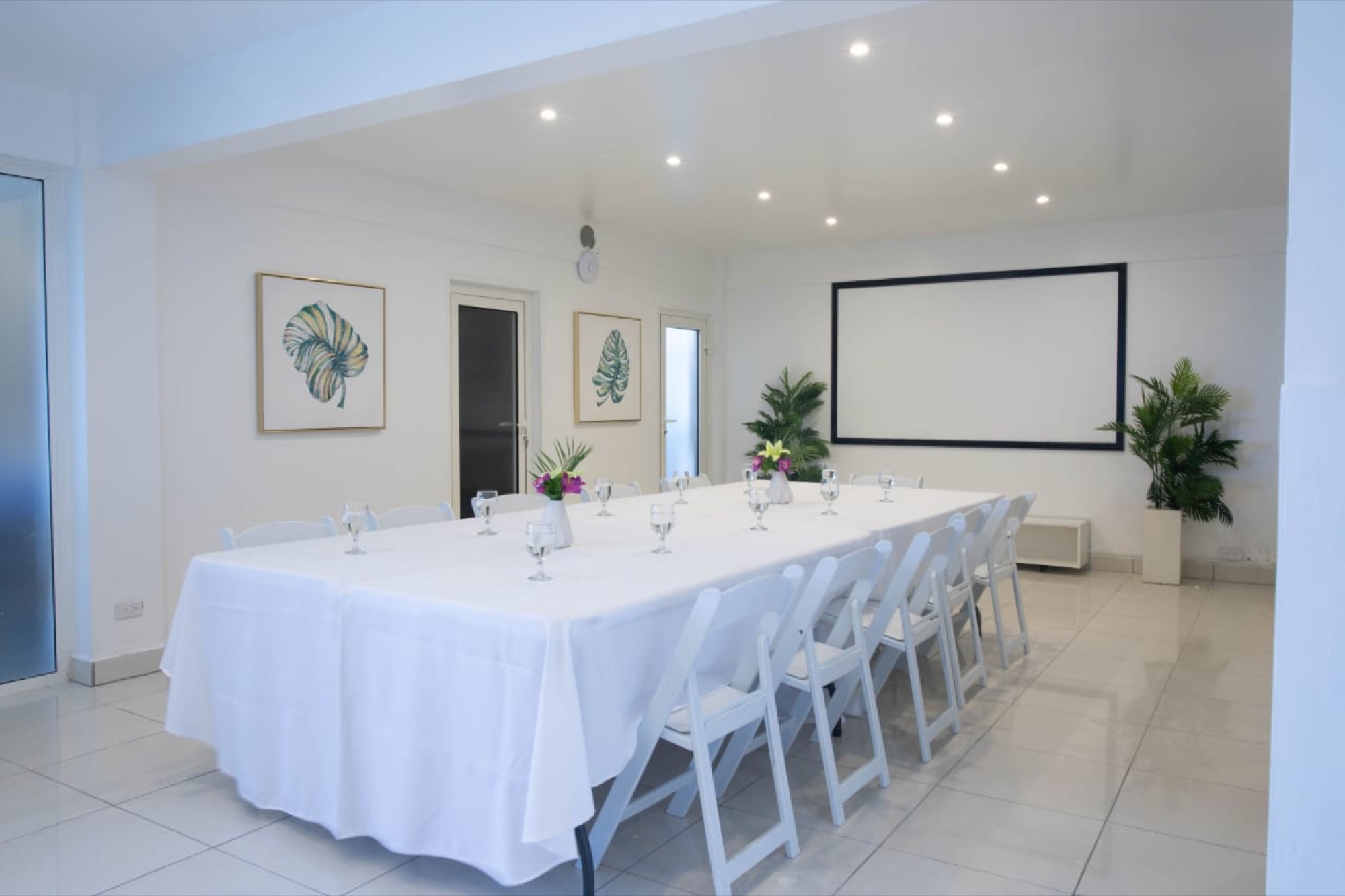 Aida Hall set for a banquet with white linen and a presentation screen