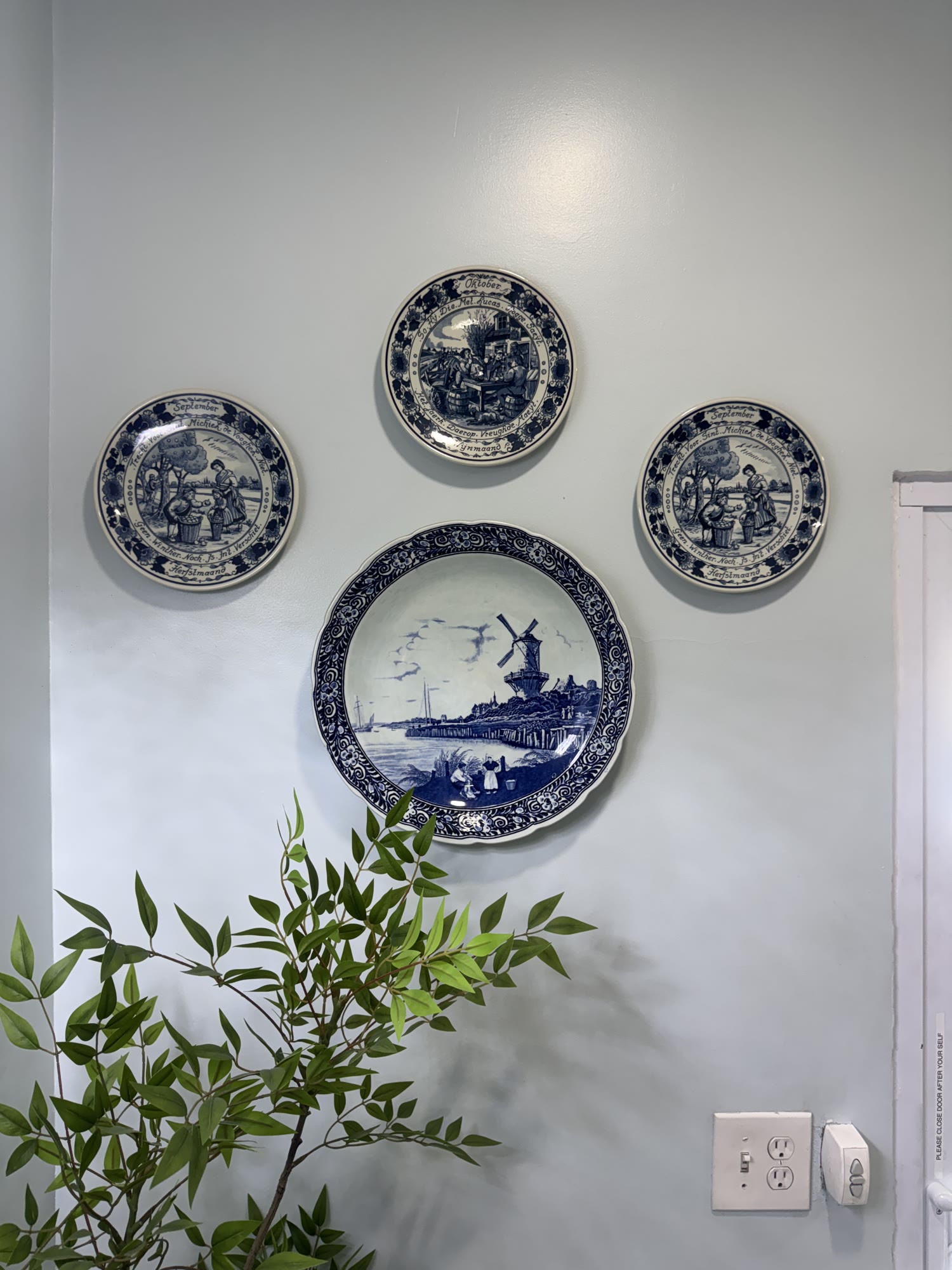 Hand-painted Delft blue-and-white plates on the wall — a European note