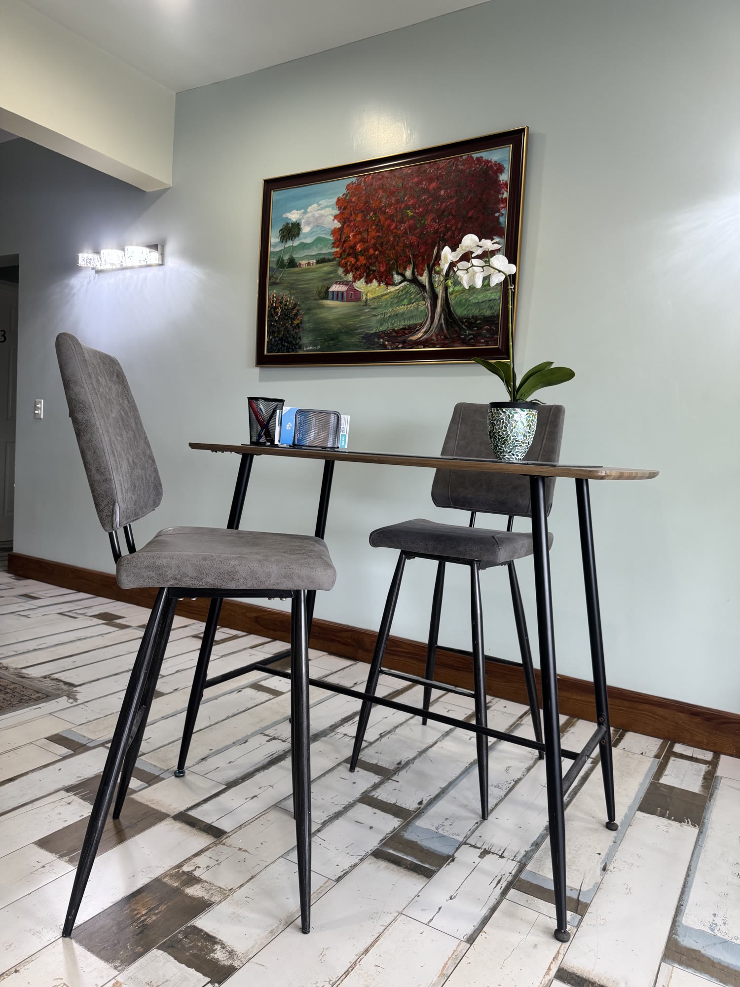 A bar-height work counter at BethsAida — grey stools and a plug socket within reach for a stand-up session