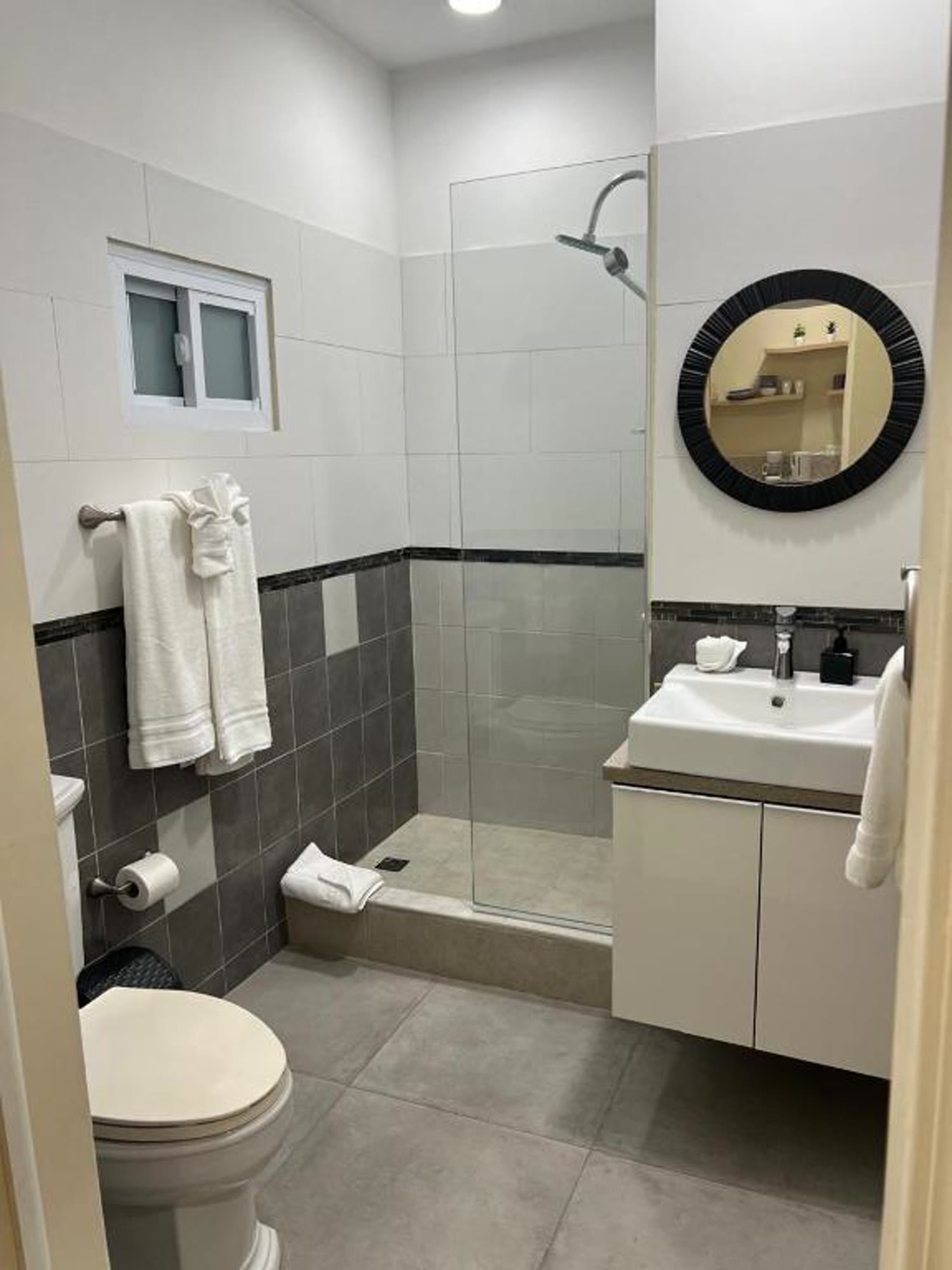 A BethsAida guest room with a bed, work desk and warm island palette